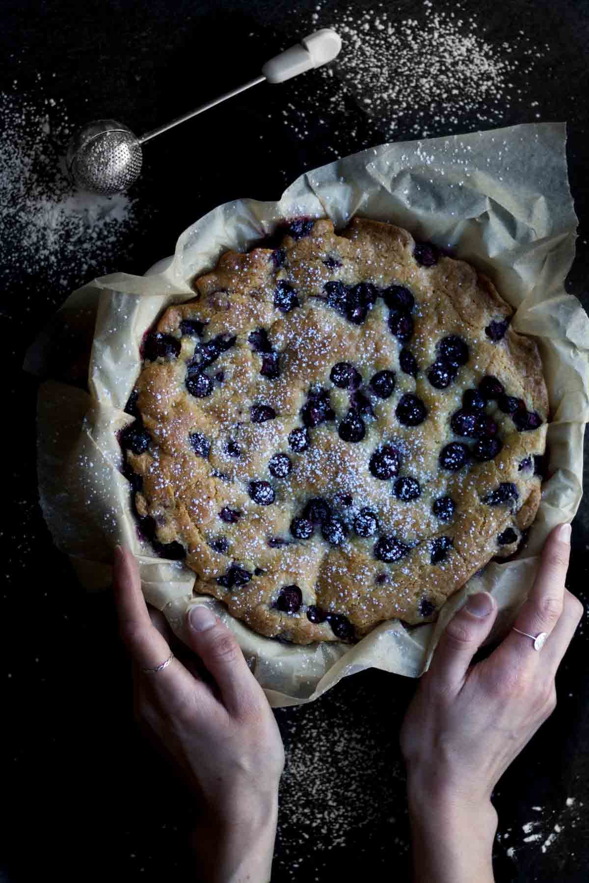 A gluten free Vegan Olive Oil Cake dusted with confectioners’ sugar.