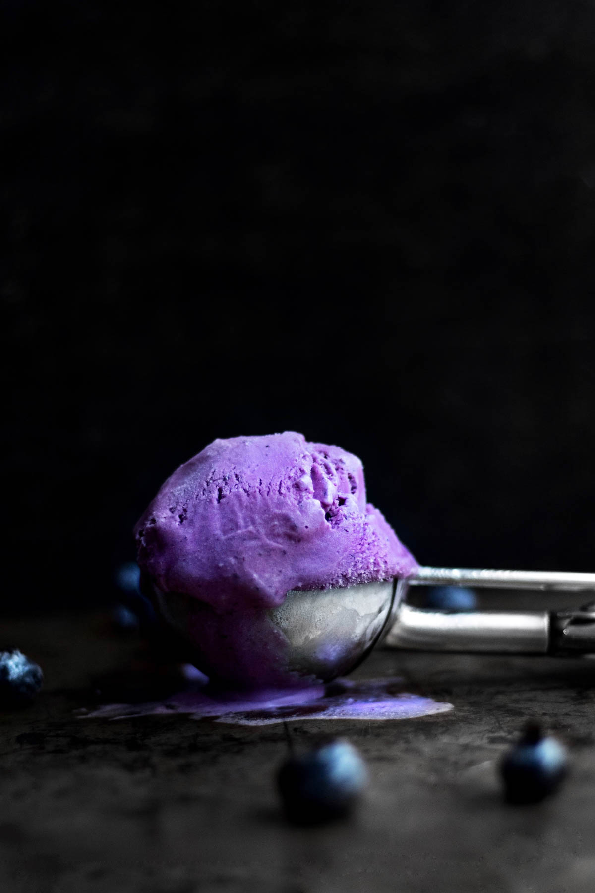 A scoop of purple Blueberry Ice Cream sits in a scoop.