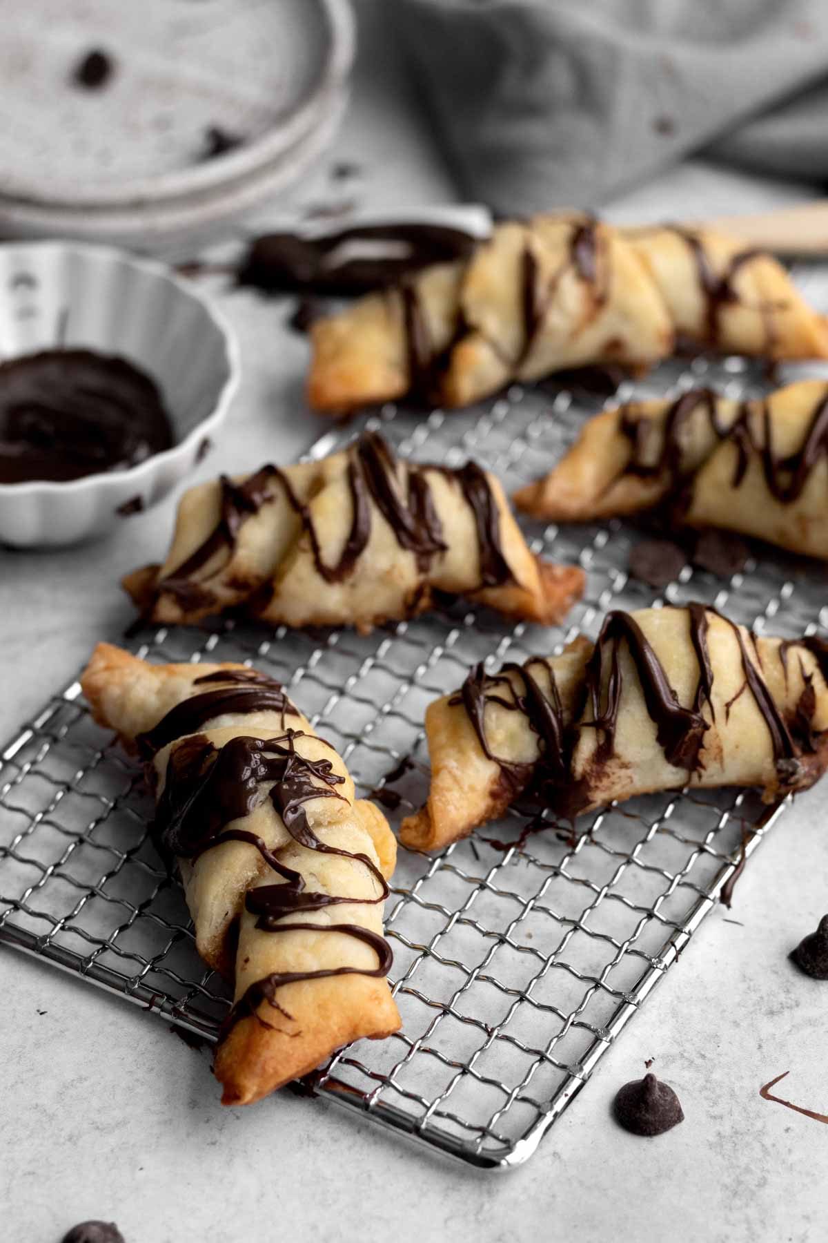 Five gluten free Puff Pastries with Chocolate drizzled in chocolate.