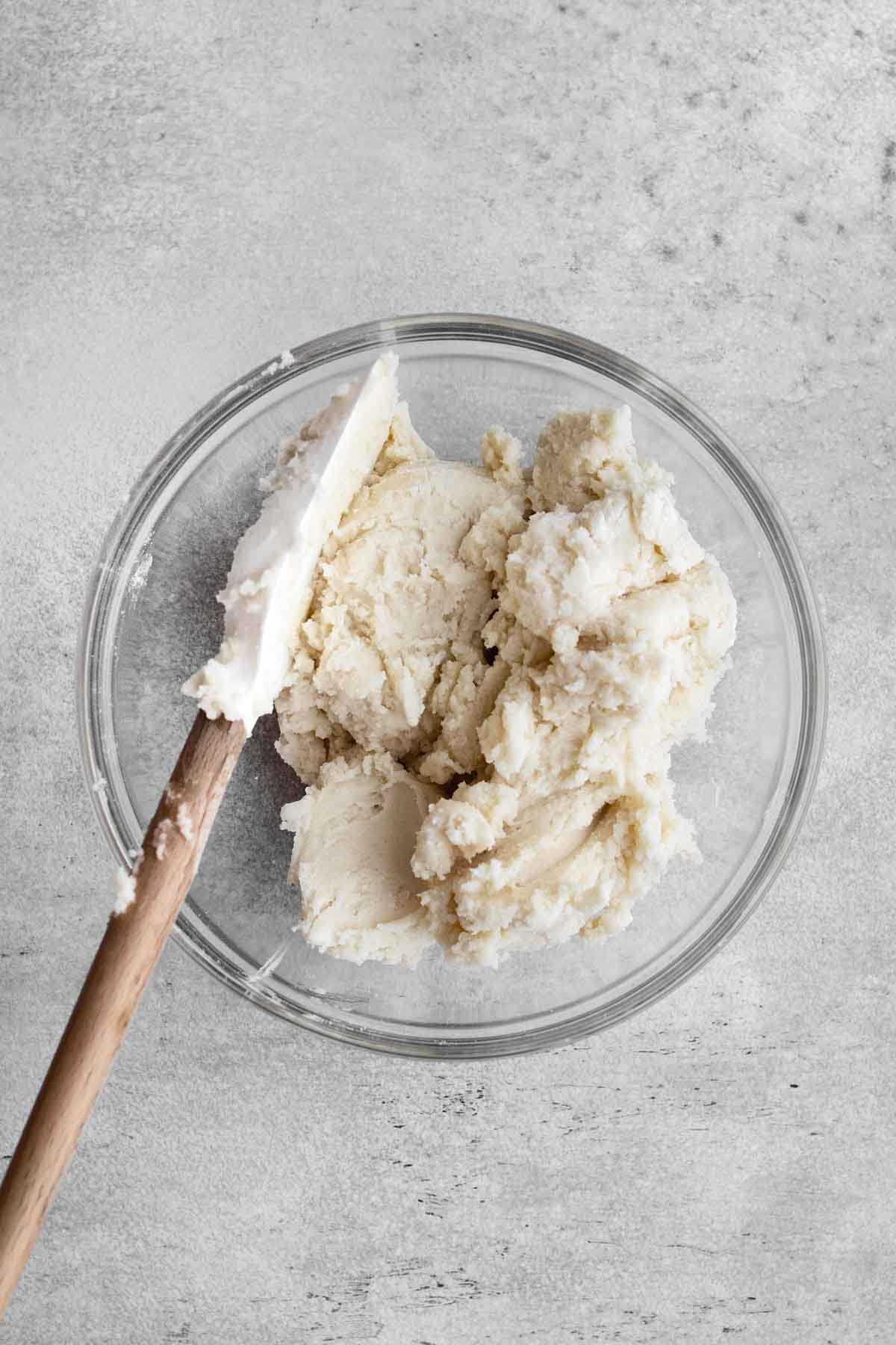 The wet and dry ingredients mixed together with a rubber spatula in a glass bowl.