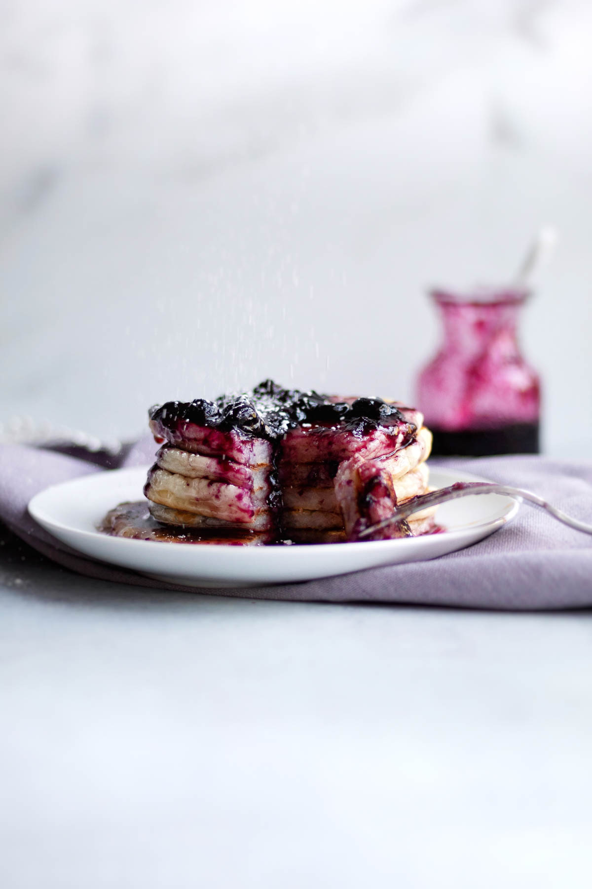 A stack of Gluten Free Pancakes topped with a blueberry jam.
