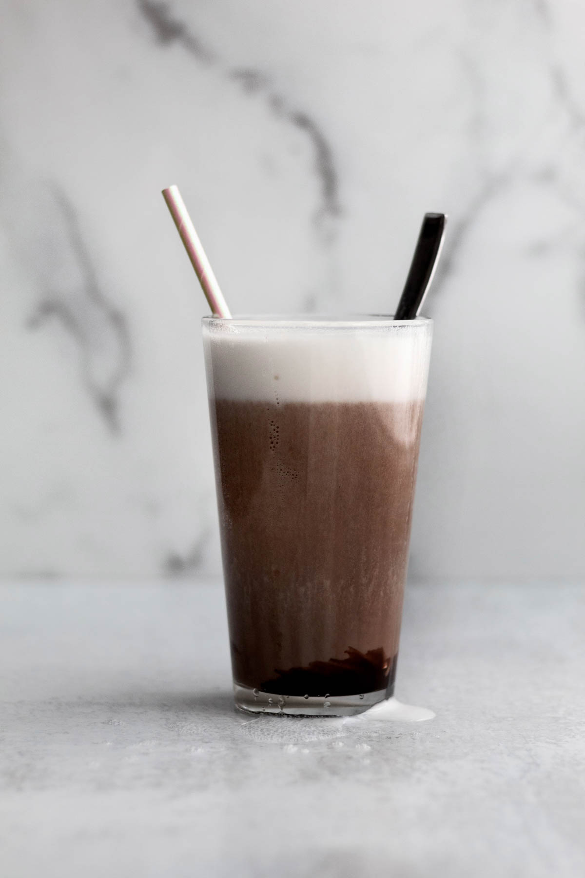 A mixed New York Chocolate Egg Cream in a glass.