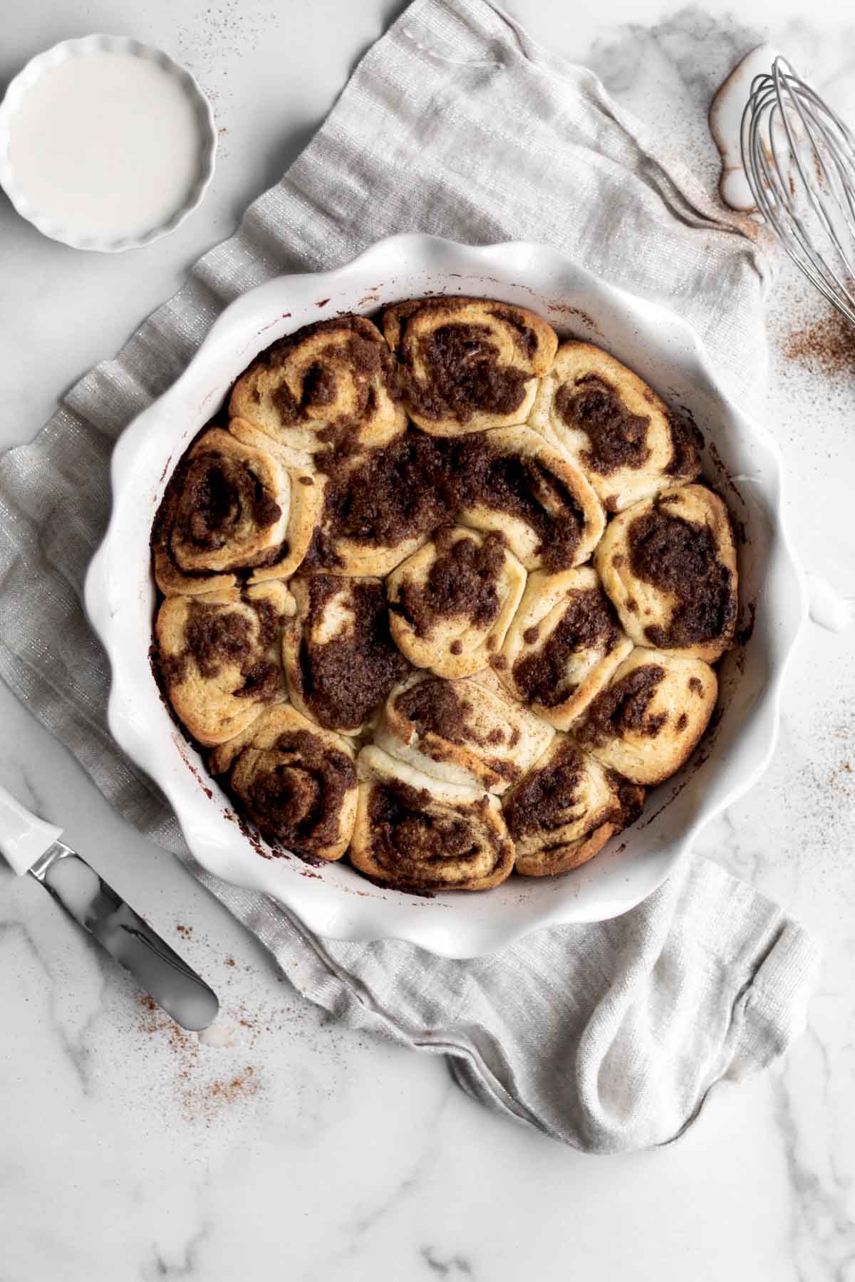 Cinnamon Rolls erupting with cinnamon and brown sugar from their swirls.