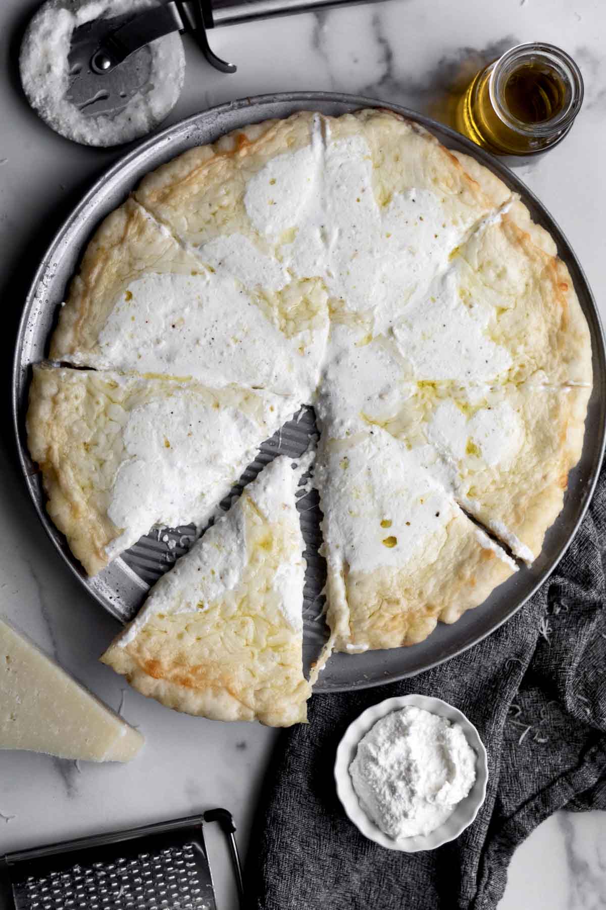 Gluten free Pizza Bianca on a pizza tray with the cheese melting.