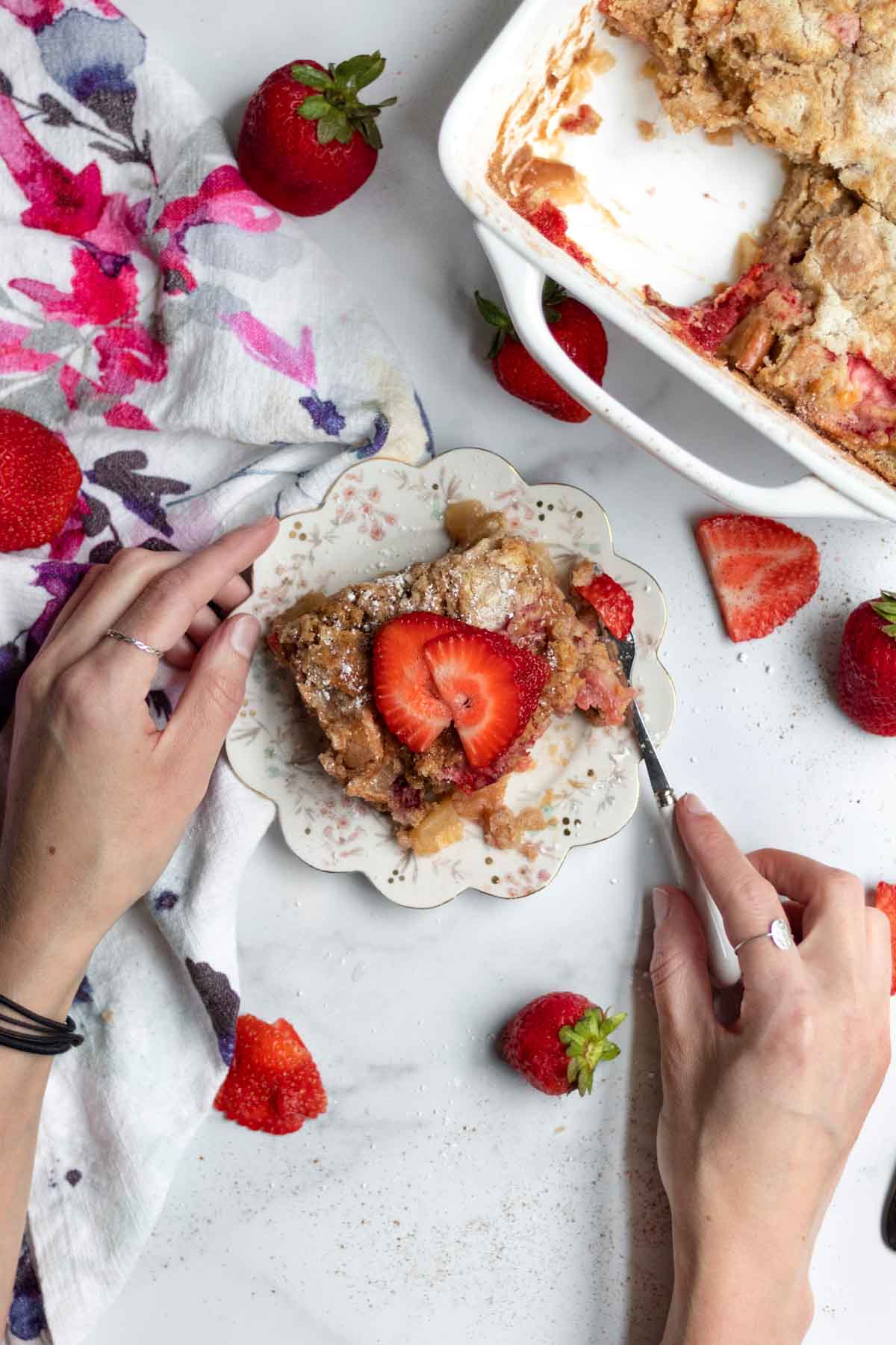 Hands using a fork on gluten free and nut free Strawberry Apple Dump Cake.