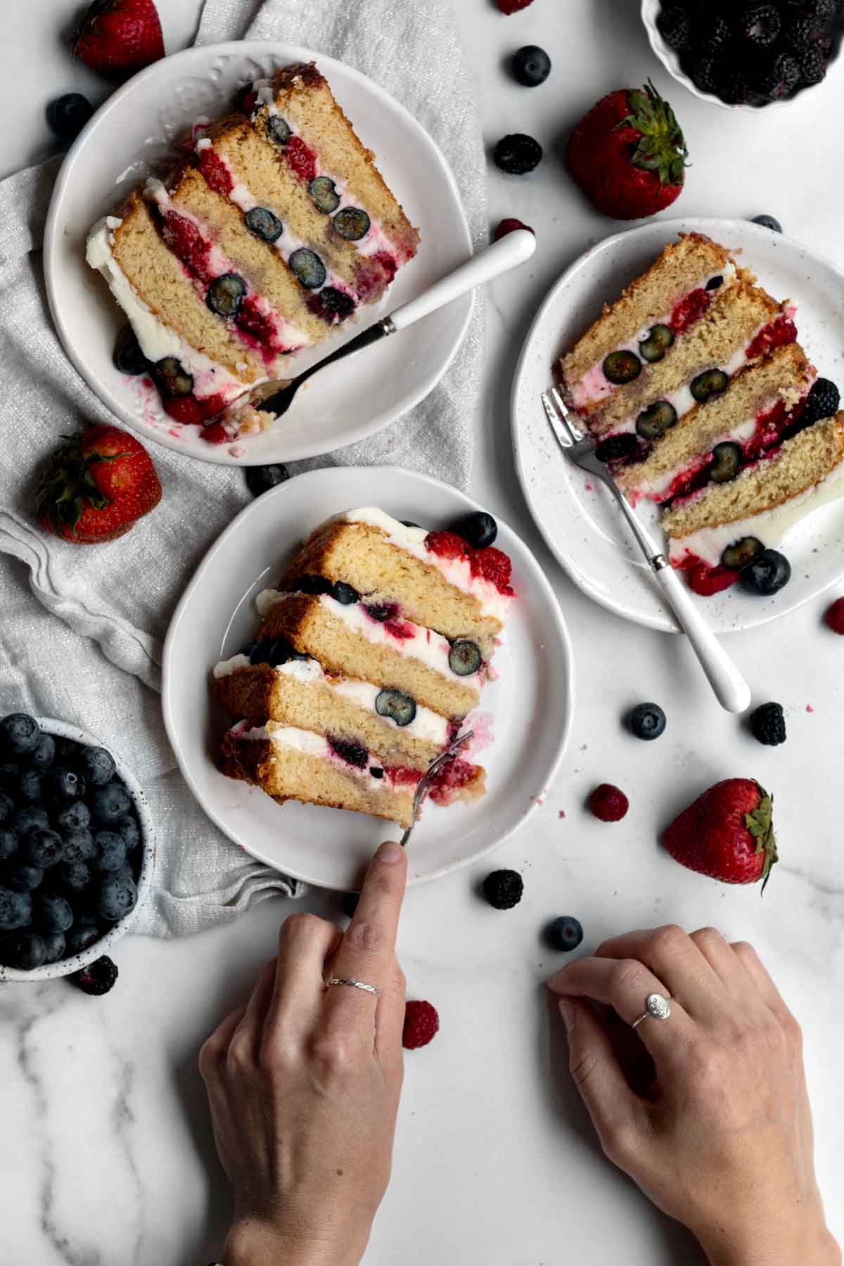 Three slices of Mixed Berry Cake on plates.