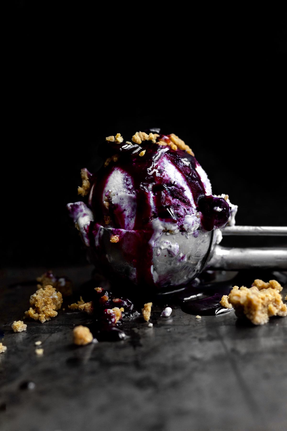 Blueberry Cheesecake Ice Cream with deep purple blueberry compote and graham crackers.