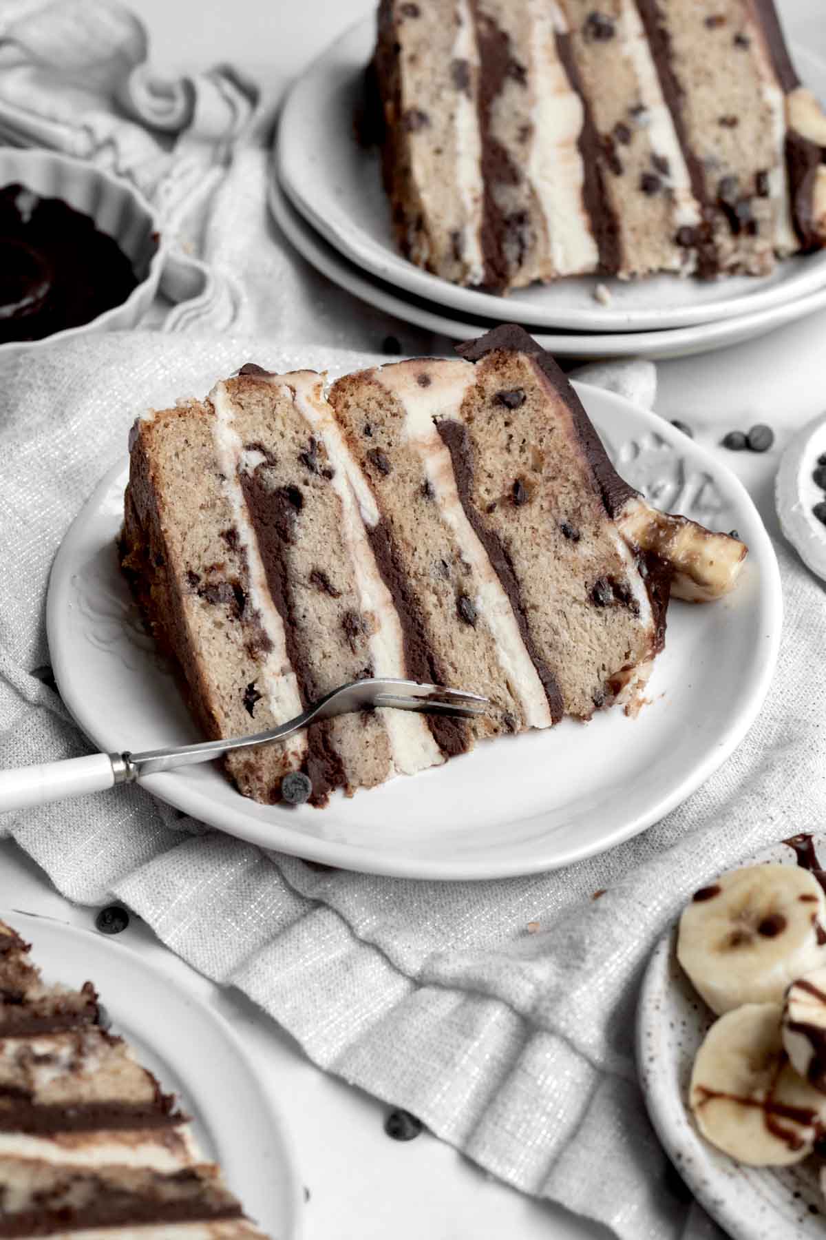 A fork cuts into the layered frosting and chocolate chip cake.