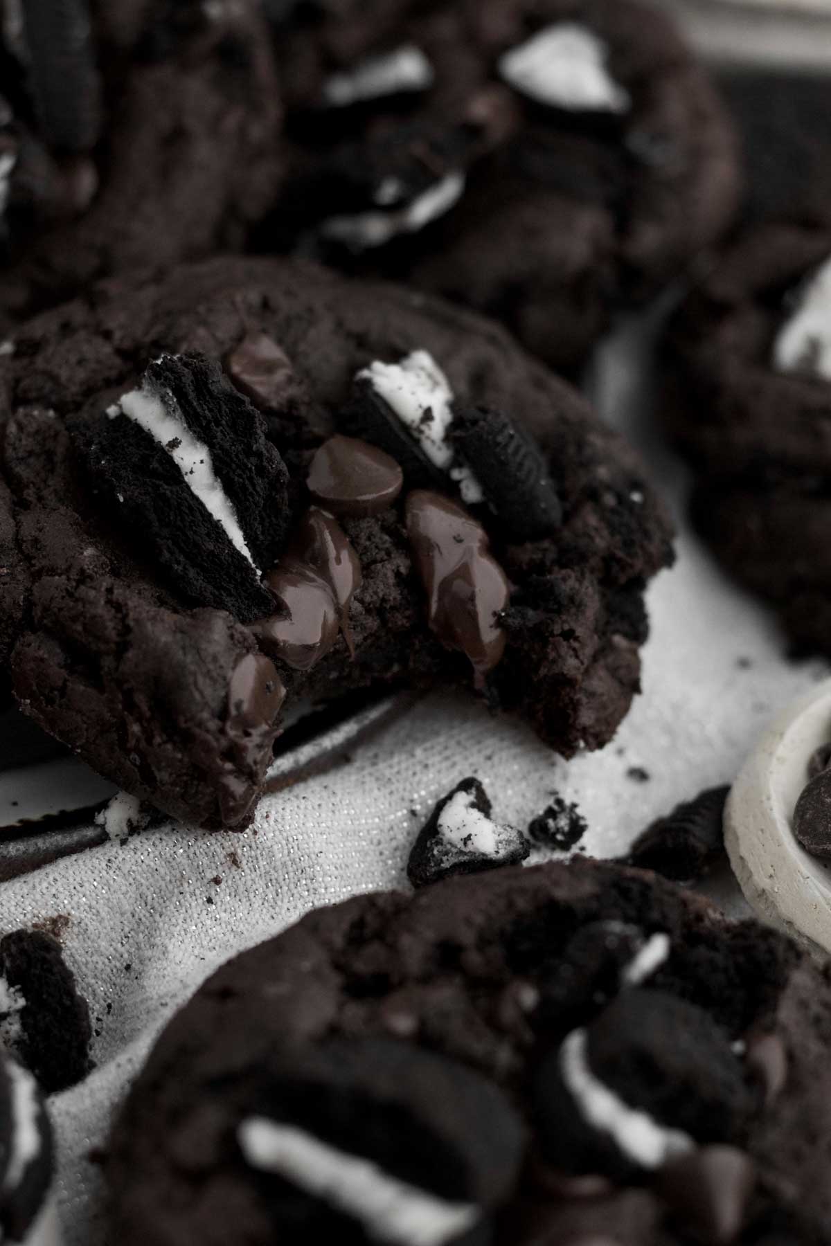 A bitten Chocolate Cookies and Cream Cookie reveals a cascade of melted chocolate and delicious interior.