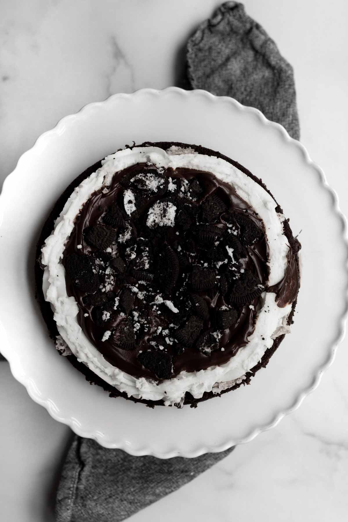 Adding a layer of broken sandwich cookies on the cake top.