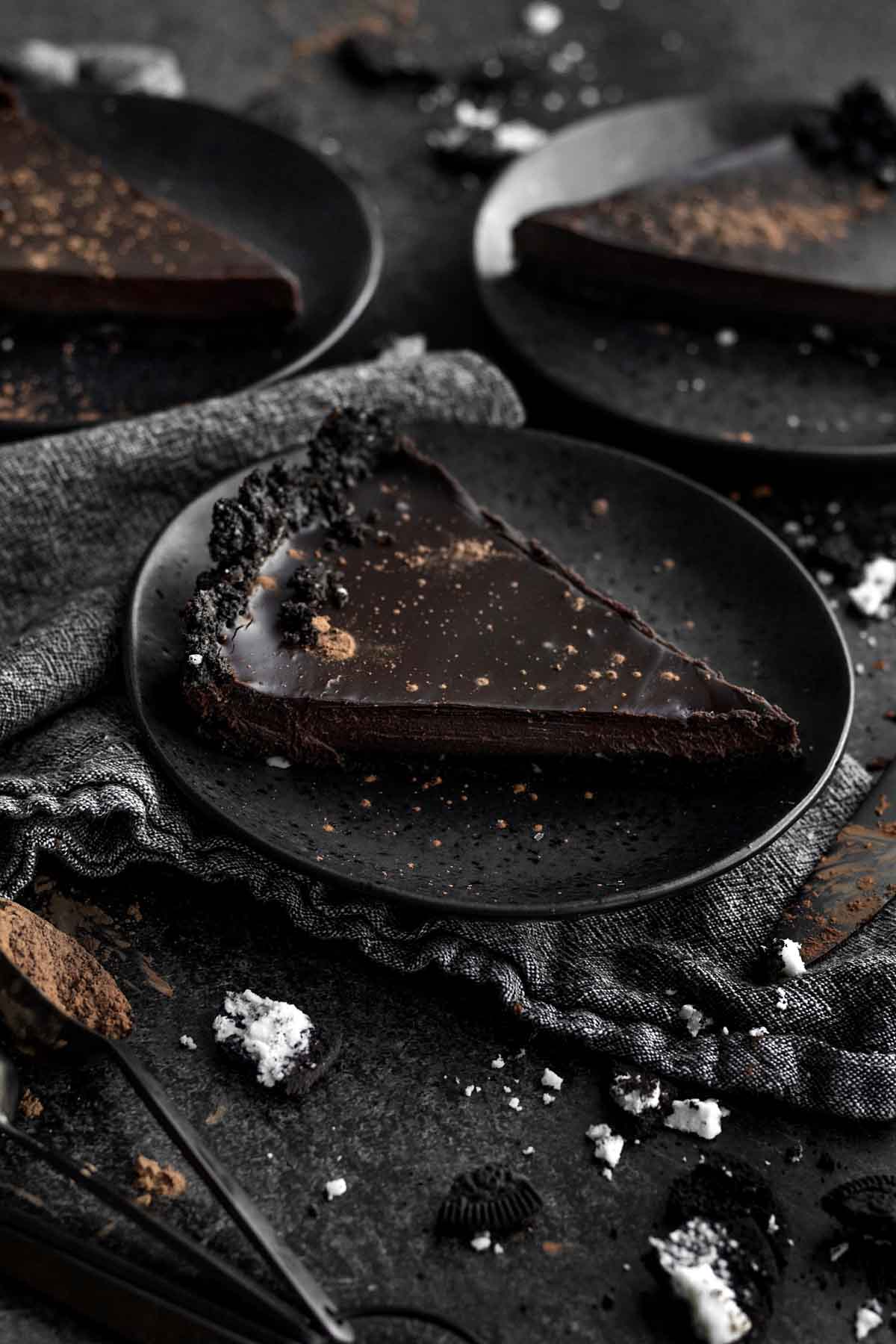 A dark, frilled and thin slice of Chocolate Ganache Tart.