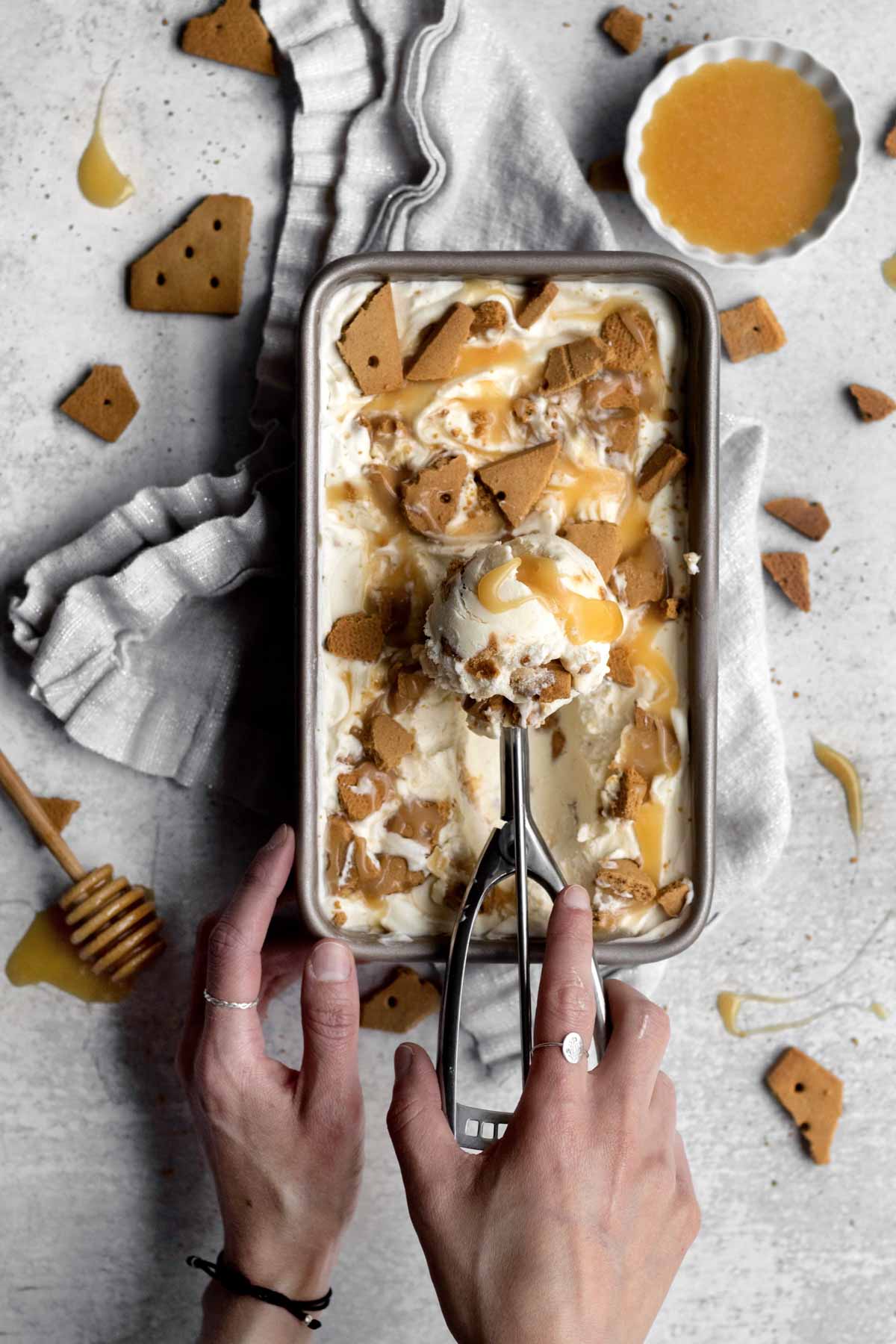 Taking a scoop of frozen Graham Ice Cream from a pan.