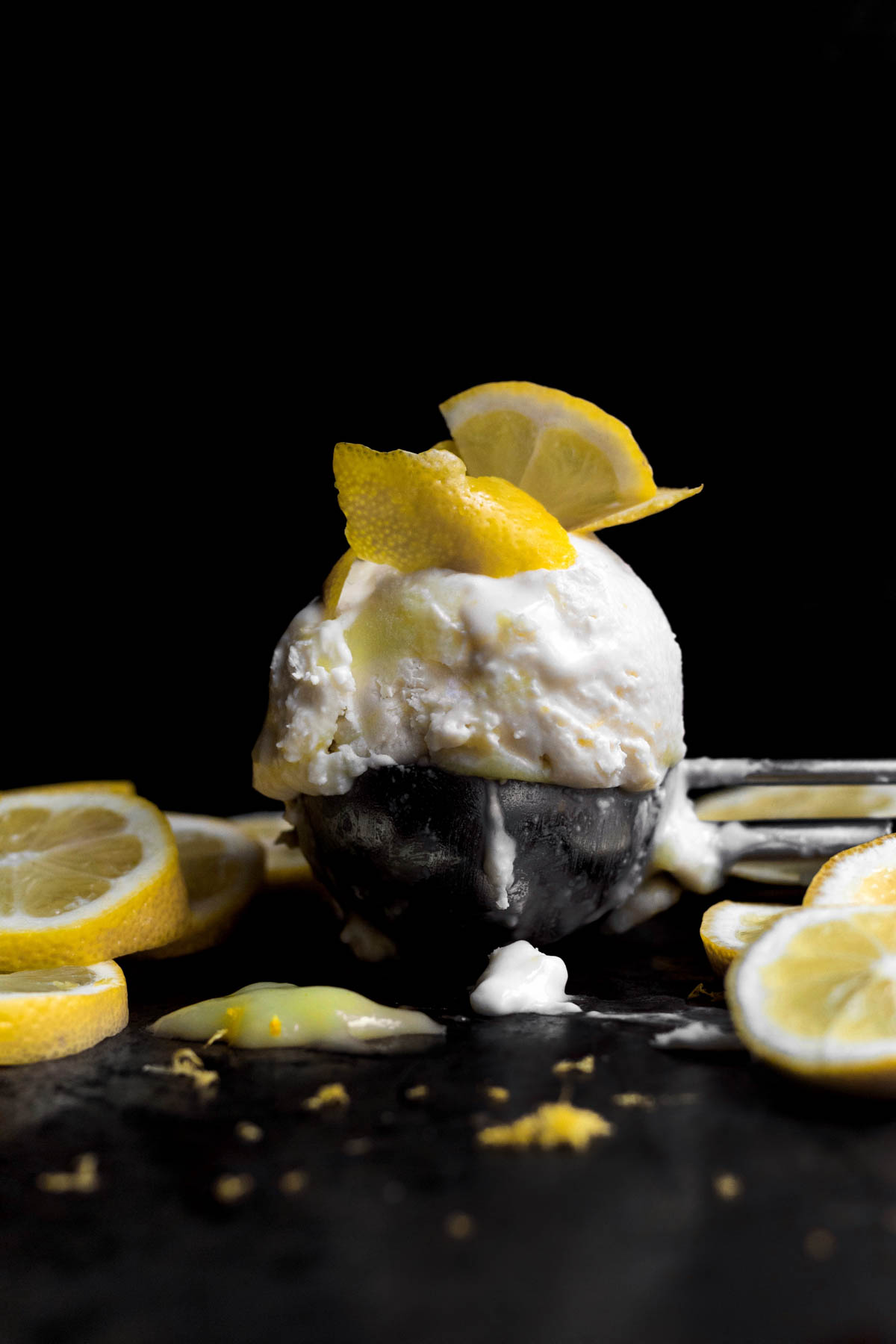 Scoop of Lemon Curd Ice Cream with extra lemons on top.