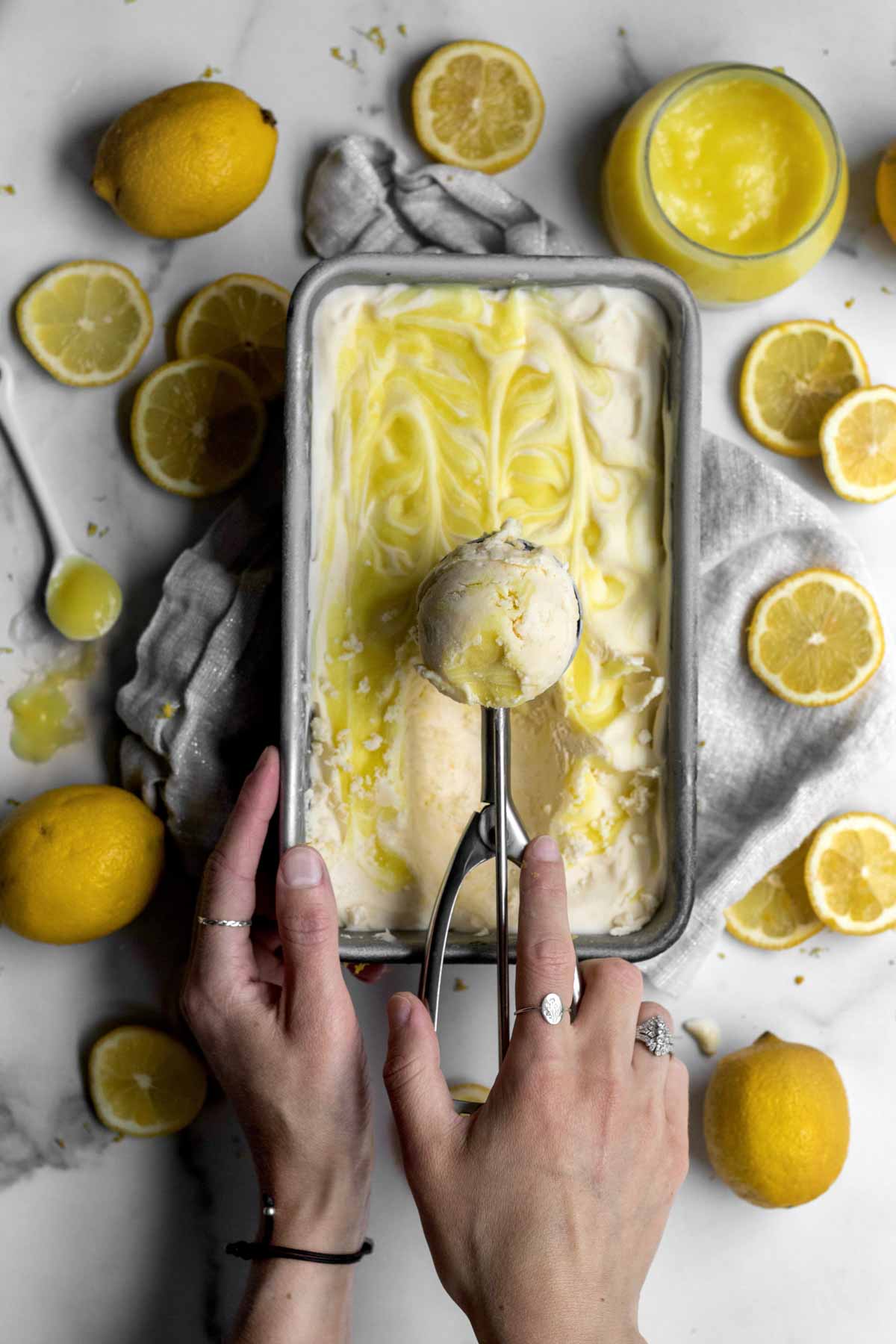 Scooping out Lemon Curd Ice Cream from the lemony swirls of the pan.