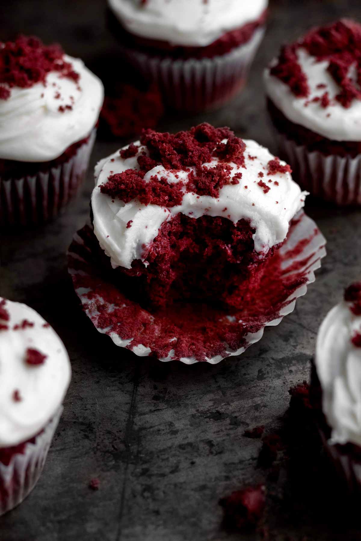 A gluten free Red Velvet Cupcake with a bite taken out.