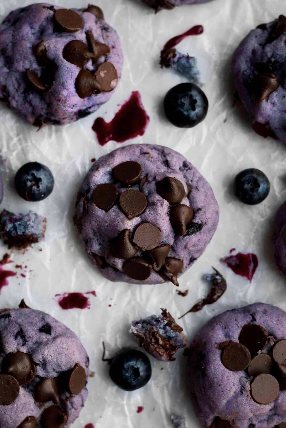 Lavender Blueberry chocolate chip Cookies with brown chocolate chips on parchment paper.