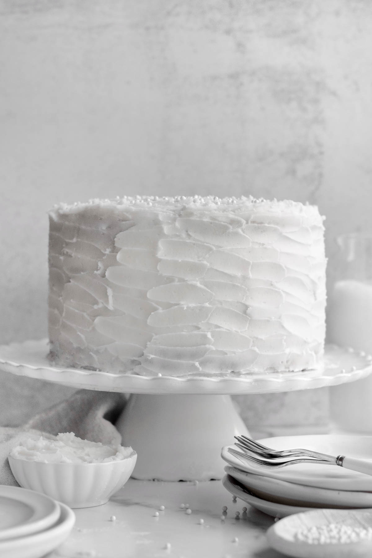 This Gluten Free Vanilla Cake sits covered with delicious white frosting.