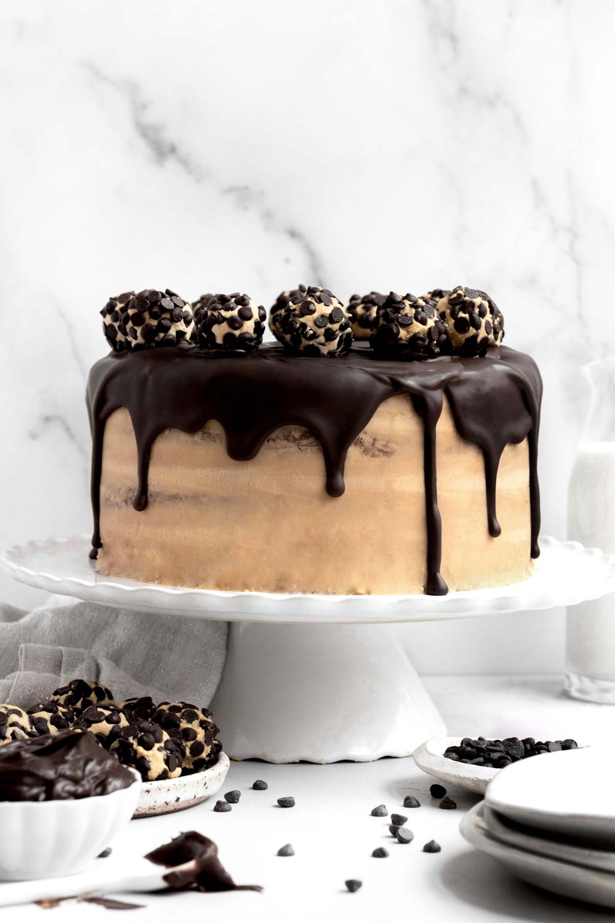A cake with balls of chocolate chip coated buttercream on chocolate ganache.