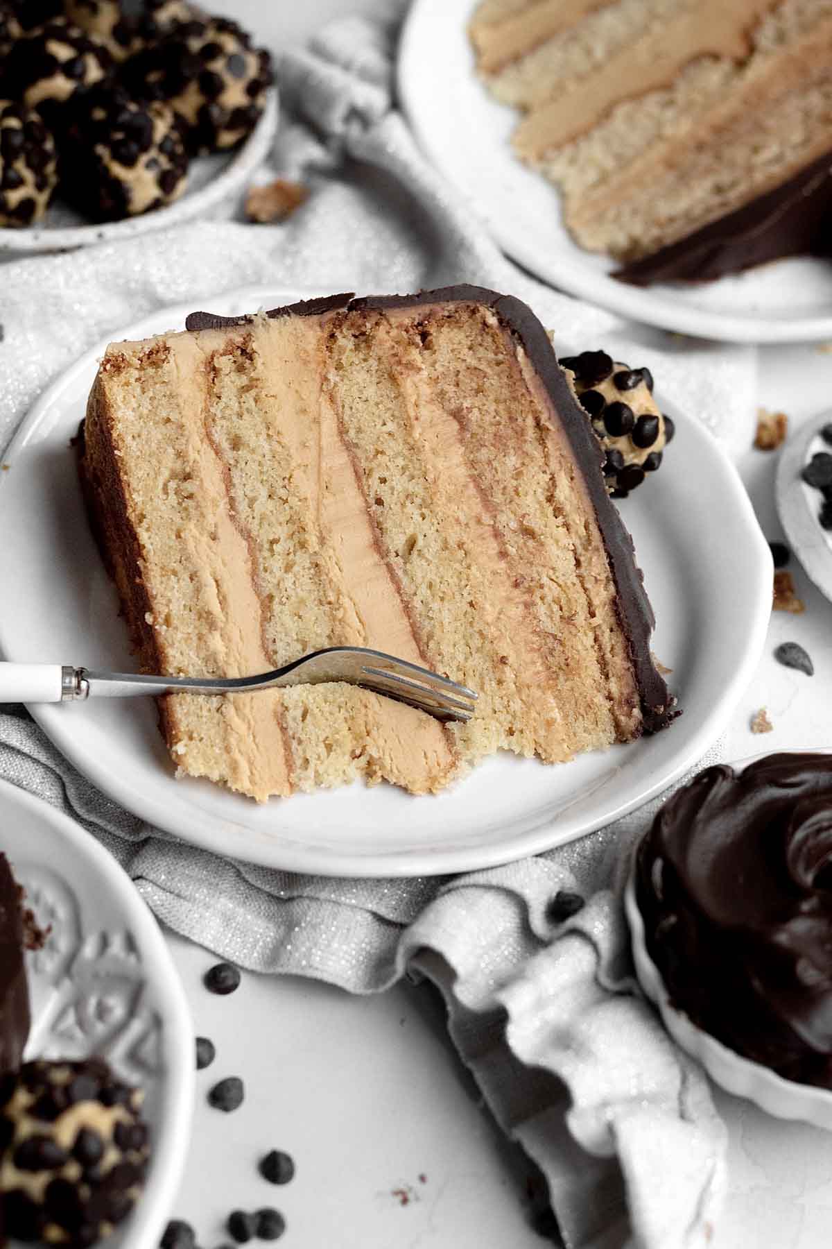 A fork ready to cut through the buttercream and golden cake.